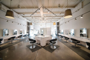 A modern hair salon interior in Waukee or Urbandale with sleek chairs, mirrors, and counters—perfect for balayage, highlights, hair extensions, bridal hair, and permanent jewelry.