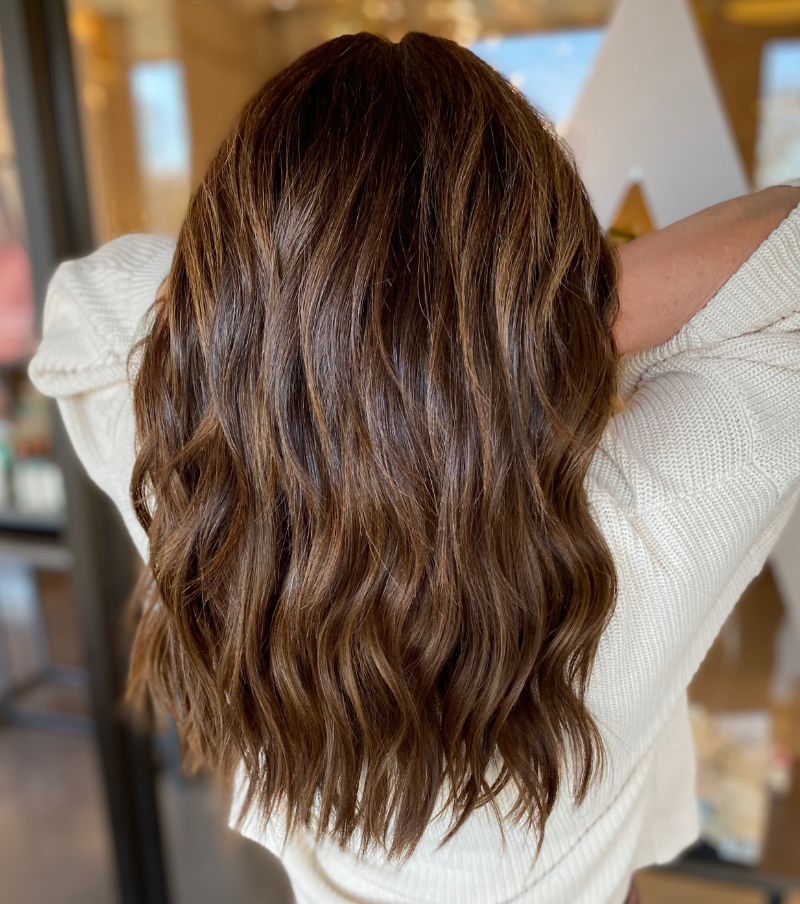 - Art of Life Salon & Spa at Urbandale and Waukee, IA Client with medium-length, wavy brown hair and highlights wearing a cream sweater at the best salon in Waukee for balayage. - Art of Life Salon & Spa at Urbandale and Waukee, IA